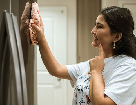Mujer limpiando con un paño la nevera